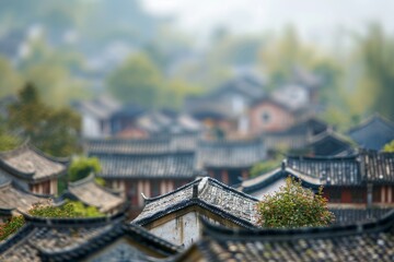 Naklejka premium Nestled in a mountainous area, traditional houses with tiled roofs are partially obscured by mist and lush greenery, creating a serene morning atmosphere.