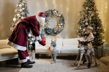 Obraz premium Santa claus giving christmas gift to child