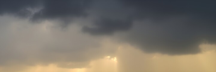 Dramatic cloudy sky with sunlight piercing through in a moody atmosphere