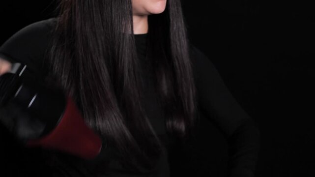 Hairdresser using blow dryer and round brush on client with long hair