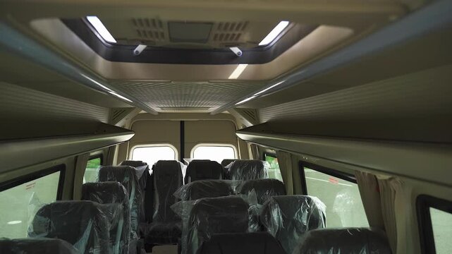 The interior of a minibus comes to life as soft lights are switched on, revealing a spacious yet cozy atmosphere.
