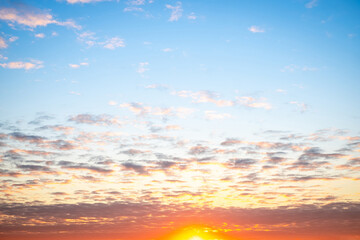 Fototapeta premium Sky,sunset, beautiful , luxury soft gradient orange gold clouds and sunlight on the blue sky perfect for the background, Sunrise on morning or everning in winter warm time ,Twilight summer,silhouette