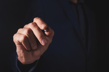 Fototapeta premium businessman holds pen in hand and presses on screen