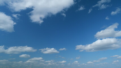 Floating fluffy cumulus clouds. Beautiful sunny blue sky with wispy smoky white stratocumulus...