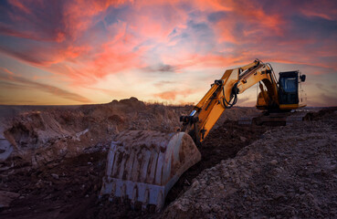 Excavator on sunset background. Open-pit mining. Backhoe dig ground in quarry. Heavy construction...