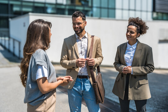 Group of modern successful business people innovative technology experts standing out of office building, discussing ideas and innovations. Leaders in global marketing strategy professional occupation