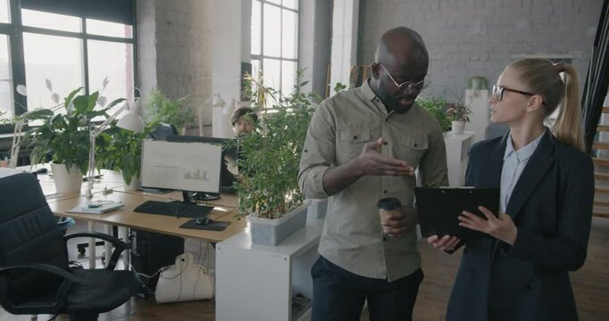 Slow motion of businesspeople man and woman talking reading document walking in coworking office. Professional occupation and business concept.