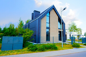 Obraz premium Barn House in suburban area. Ultra modern Architect-designed luxury house in suburb. Private Wooden Scandi home. Modern Scandinavian Barnhouse. Contemporary barnhouse villa. Barn House with fence.