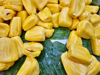 Ripe jackfruit, peeled and ready to eat, tropical fruits displayed on banana leaves