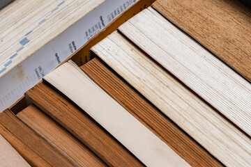 A stack of old books stored in a cardboard box, background and texture