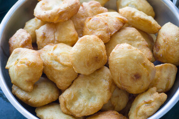 Bowl of freshly fried dough snacks, golden and crispy, perfect for breakfast or snack time.	
