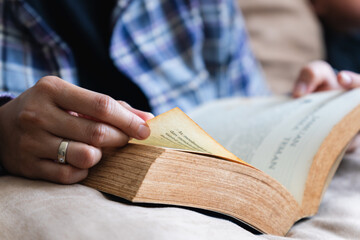 A woman flips the page of the book she is reading