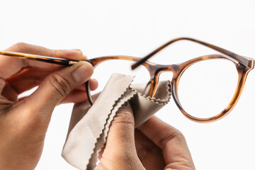 cleaning eyeglasses with microfiber cloth, in white background