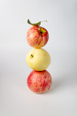 a balance of red and yellow apples on white
