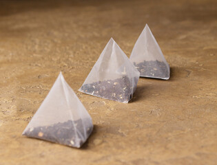 triangular tea bags on a yellow background, selective focus