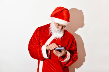 Portrait of Santa Claus on white background typing smartphone , Christmas character