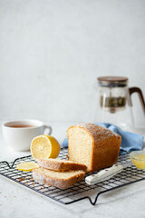 Fluffy lemon pound cake on a cooling rack over grey concrete background with a copy space for text or design