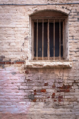 Old barred window and decaying brick work