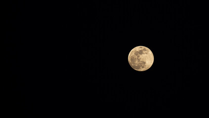 Full moon in the black sky. Close-up of the moon in the evening or night sky. Supermoon is an astronomical event.