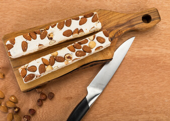Almond and hazelnut soft turron blocks on chopping board, high angle view
