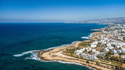 Aerial view of a coastal town with white buildings in Cyprus.