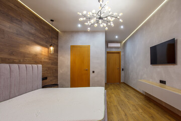 large modern bedroom bed with headboard warm wooden laminate on wall