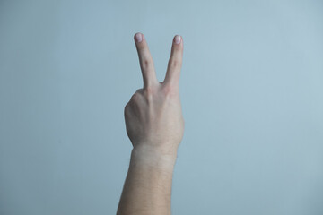 Two fingers isolated on background. Man shows his hand stop sign