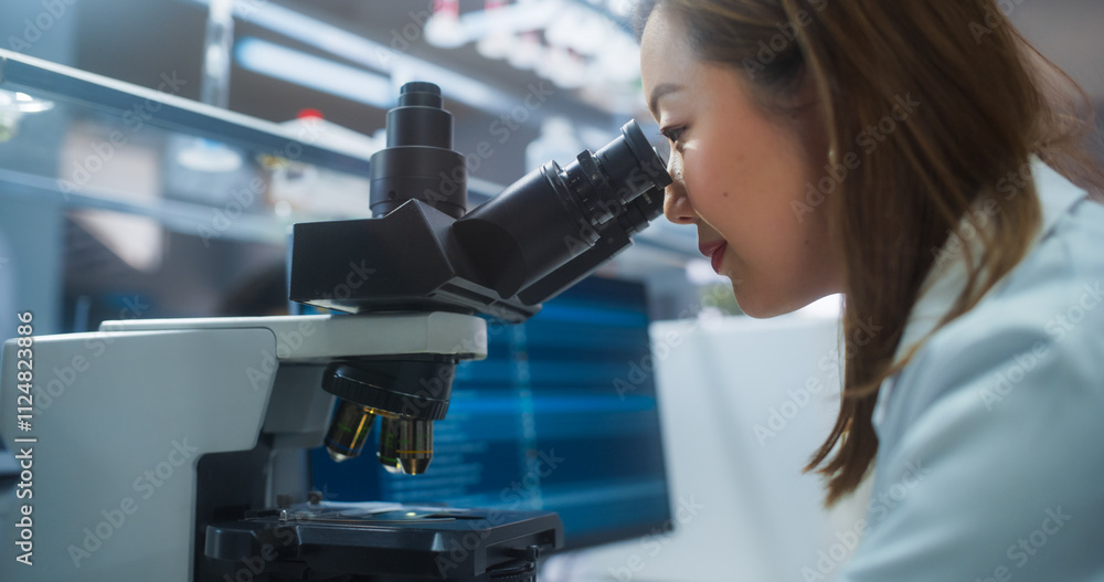 Poster medical science laboratory: japanese female microbiologist looking through the microscope, analyzing