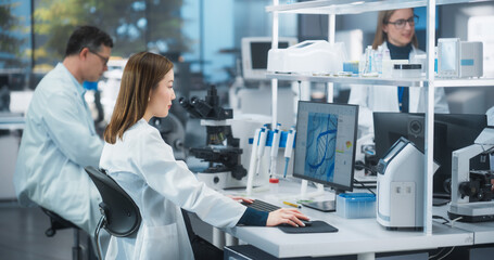 Medical Research and Development Laboratory: Motivated Asian Female Scientist Working on a Computer with Advanced DNA Diagnostic Software on Display. Modern Genetic Engineering Lab