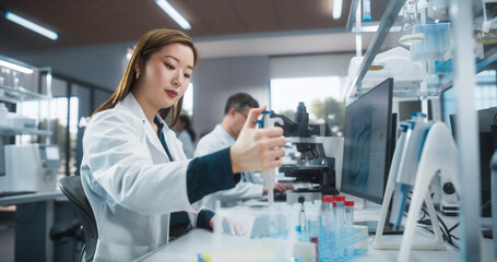 Medical Research Laboratory: Portrait of a Beautiful Japanese Female Scientist Using Micro Pipette for Test Analysis. Advanced Scientific Lab for Medicine, Biotechnology, Microbiology Development