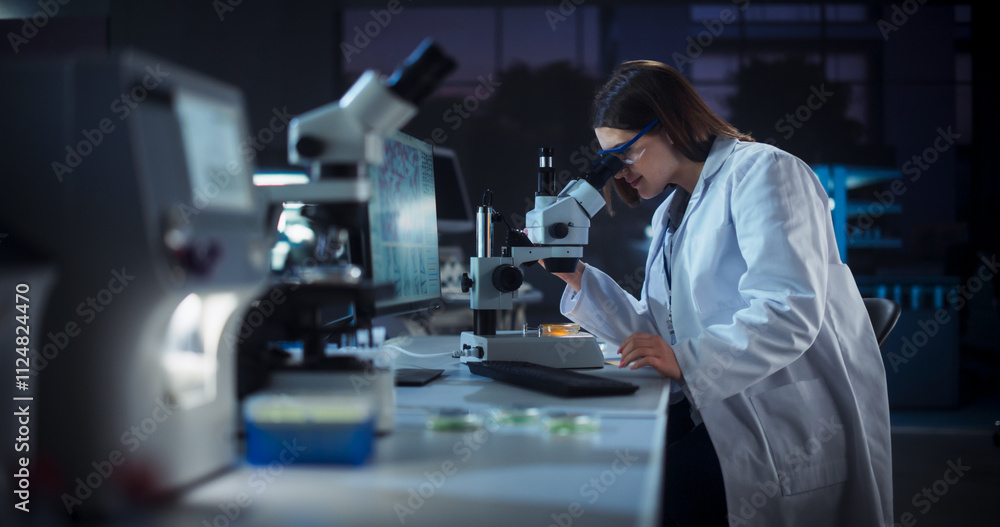 Poster Medical Research and Development Laboratory: Hard-Working Female Scientist Using Computer and Looking at a Sample in a Petri Dish Under a Microscope. Advanced Genetic Engineering Lab at Night