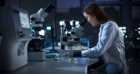 Genetic Research Scientist Using Microscope in an Applied Science Laboratory in the Evening....