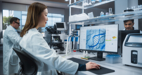 Asian Female Scientist Working on a Desktop Computer, Analyzing DNA Samples. Specialist Using a...