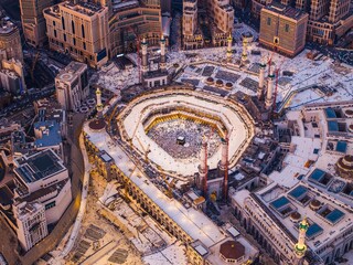 Aerial view showing crowds of pilgrims gathered around the Kaaba in the Grand Mosque, with construction cranes surrounding the site in Mecca (Makkah) © Collab Media
