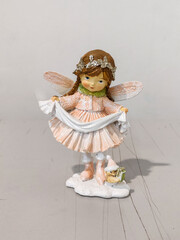 A small figurine of a fairy holding a blanket