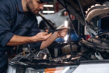 Cable installation. Mechanic working in a car service station