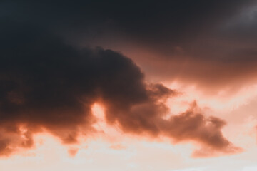 Sunset storm clouds with vivid rays breaking through, creating a dramatic and atmospheric...