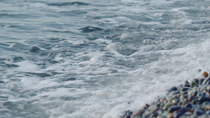 Sea Waves Break On Pebble Beach. Wave Motion On The Shoreline With Foam And Pebble.