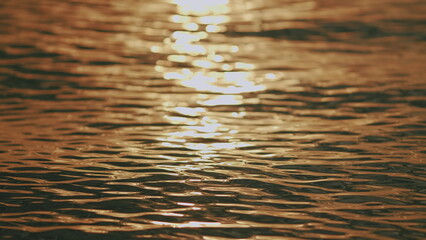 Close up. Sun Reflections At Water Surface. Beautiful Defocused Abstract Blurry Sea Water Background.