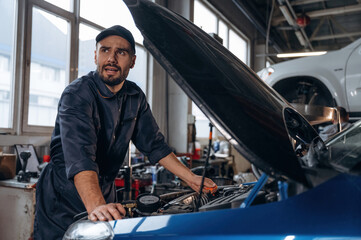 In the cap, busy. Mechanic working in a car service station