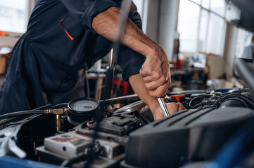 Opened hood. Close up view of mechanic in car service station