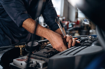 Opened hood. Close up view of mechanic in car service station