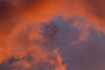 Moody storm clouds illuminated by vibrant sunset light—an inspiring backdrop for artistic or...
