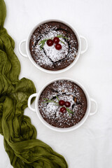 chocolate desserts beautifully garnished with fresh cherries and rosemary leaves for elegance with green napkin.