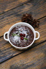 An Elegant Chocolate Dessert Beautifully Served in a White Bowl with a Garnish on Top on wooden table.