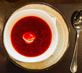 Beetroot soup with sour cream in bowl. Top view