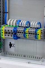 Electrical screw through terminals with connected insulated wires in an electrical switchboard.