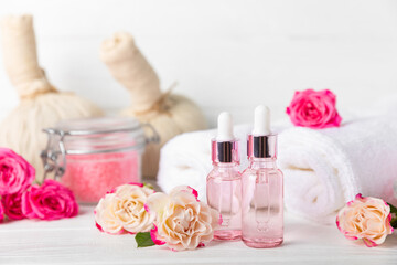 Rose essential oil on a textured background.Roses and a bottle of rose perfumed water.Aromatherapy treatment. Beauty concept. Spa procedure.Natural organic oil.Anti-stress,detox relax.Place for text