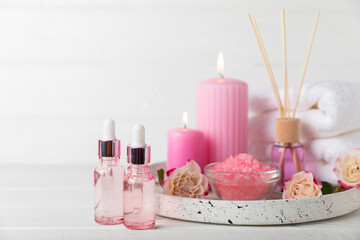 Rose essential oil on a textured background.Roses and a bottle of rose perfumed water.Aromatherapy treatment. Beauty concept. Spa procedure.Natural organic oil.Anti-stress,detox relax.Place for text