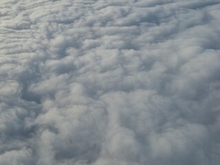 Airplane flying over white clouds background